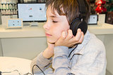 Portrait of a sweet young boy listening to music on headphones 