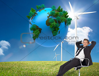 Composite image of manager relaxing in office with team in backg
