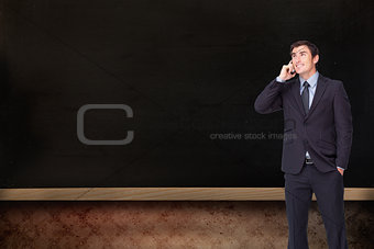 Composite image of happy businessman phoning