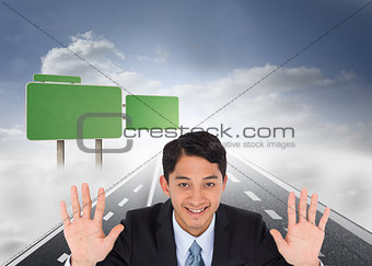 Composite image of smiling asian businessman holding hands up