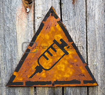 Syringe Icon on Rusty Warning Sign.