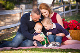 Small Young Family Opening Christmas Gifts in the Park