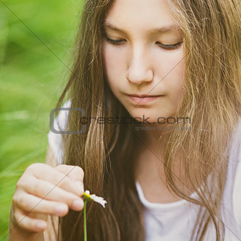 young girl wonders on camomile