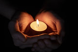 female teen hands holding burning candle