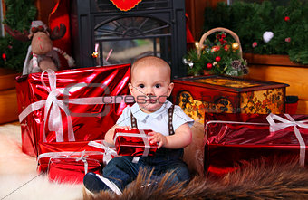 Cute baby boy with Christmas gifts