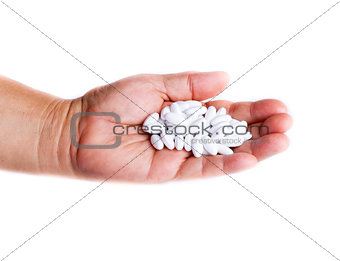 Adult holding white pills in hand