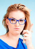 Young Woman with Blond Hair and glasses Lifting her Finger 