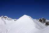 Snowy off-piste slope and blue clear sky at nice winter day