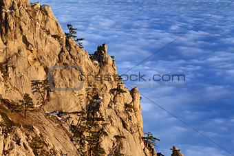Sunlit cliffs and sea in clouds at evening