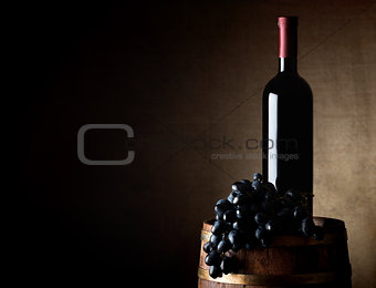 Wine and grape on a barrel