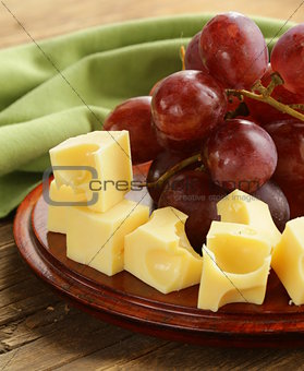 wooden plate with cheese (Maasdam)