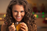 Portrait of happy young woman with cup of ginger tea