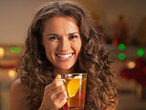 Portrait of smiling young woman with cup of ginger tea