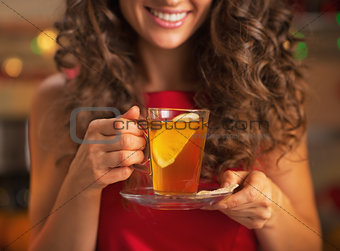 Closeup on happy young woman with cup of ginger tea