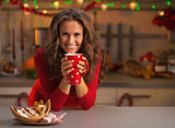 Young woman having christmas cookies in kitchen