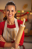 Portrait of smiling young housewife with rolling pin