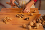 Closeup on young housewife chopping walnuts