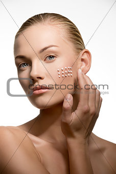 woman applying cosmetics on visage 