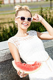 girl in white summer dress eat watermelon