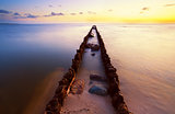 long wooden dike in North sea at sunset