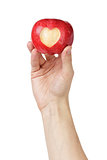 adult man hand holding apple with carved heart