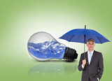 Composite image of businessman smiling at camera and holding blue umbrella