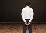 Composite image of rear view of young businessman wearing handcuffs