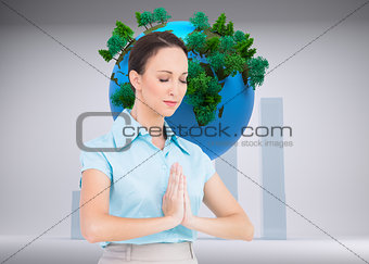 Composite image of peaceful young businesswoman praying