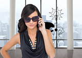 Composite image of serious elegant brunette wearing sunglasses on the phone