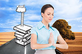 Composite image of peaceful young businesswoman praying