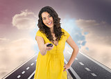 Composite image of smiling curly haired pretty woman changing channel with remote