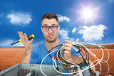 Composite image of portrait of confused it professional with screw driver and cables in front of ope