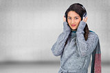 Composite image of beautiful model wearing winter clothes listening to music