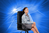 Composite image of portrait of a serious businesswoman sitting on an armchair