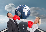 Composite image of businesswoman hitting colleague with her boxing gloves