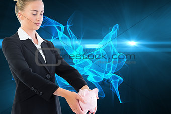 Composite image of businesswoman holding piggy bank