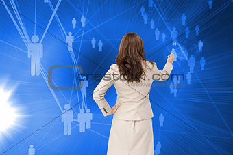 Composite image of businesswoman standing back to camera writing with marker
