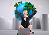 Composite image of businesswoman sitting in front of laptop with arms up