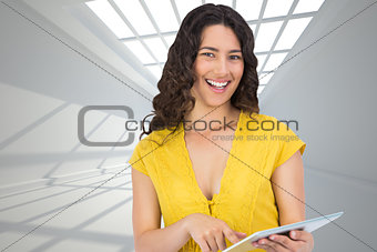 Composite image of smiling casual young woman scrolling on her tablet computer
