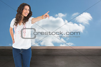 Composite image of cheerful attractive brunette wearing casual clothes pointing