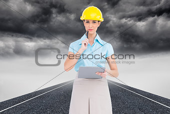 Composite image of thoughtful attractive architect holding clipboard