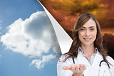 Composite image of portrait of female nurse holding out open palm