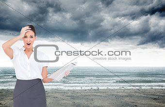 Composite image of shocked classy businesswoman holding newspaper