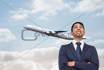 Composite image of smiling asian businessman with arms crossed