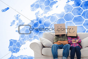 Composite image of silly employees with arms folded wearing boxes on their heads