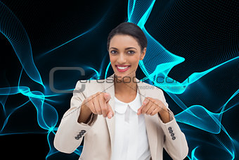 Composite image of smiling businesswoman pointing at the camera