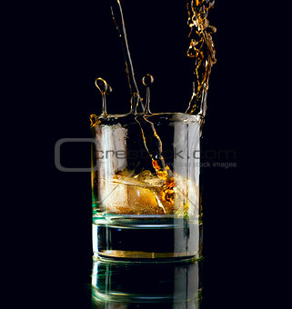 Glass of whiskey on a black background. 