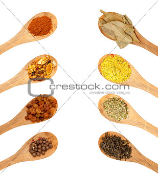 wooden spoons with seasonings on a white background