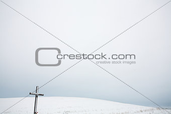 Winter landscape with snow hill and cross