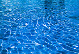 Pure blue transparent water with patches of light from the sun in pool